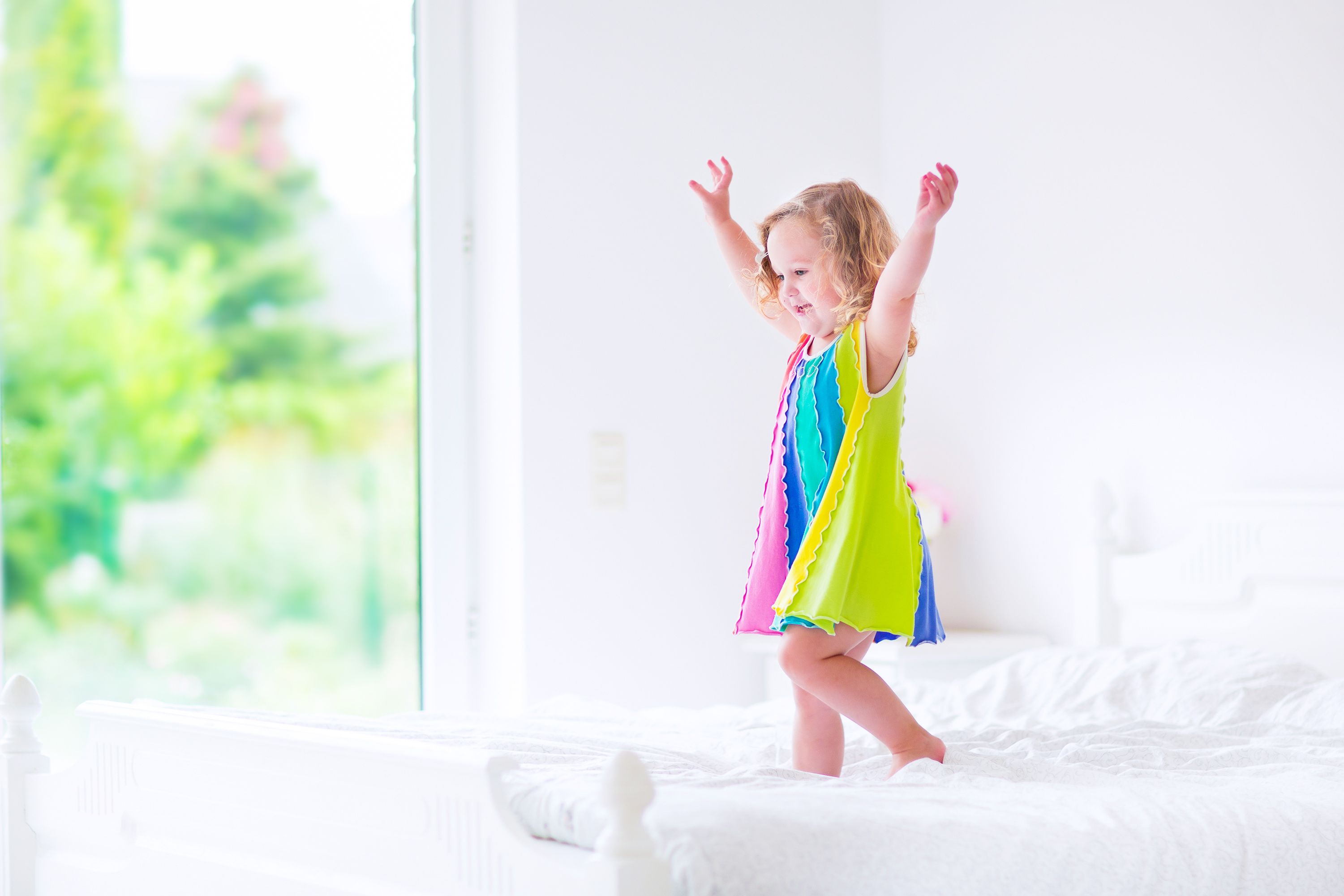 Niña jugando en la cama